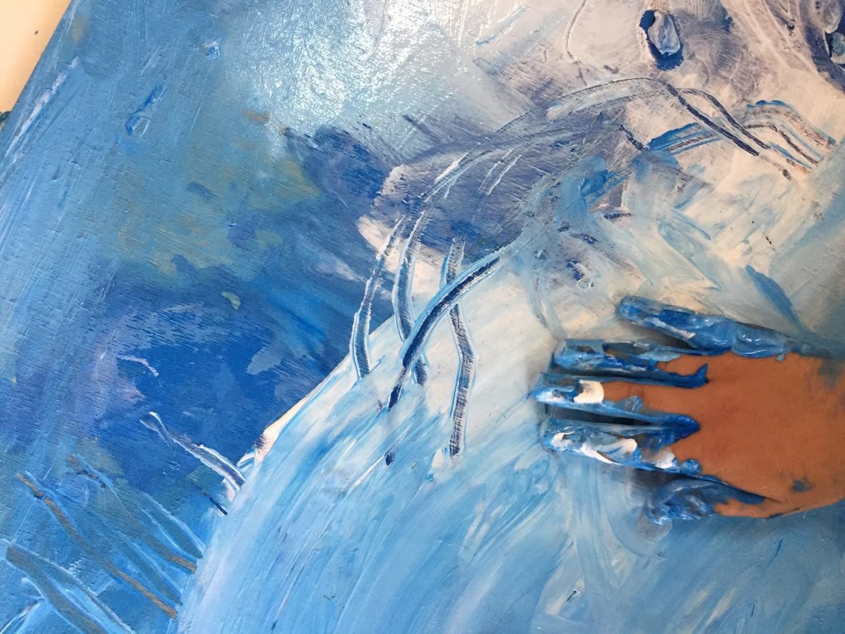 Mains couvertes de peinture bleue sur une toile